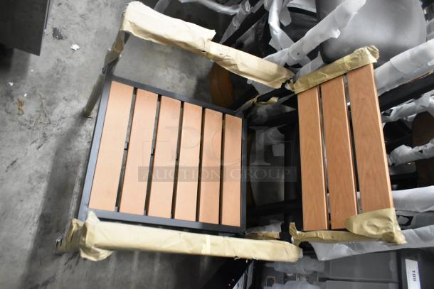 23 new Lancaster Table & Seating black metal chairs with wooden backrests, slat arm design, scratch and dent condition.