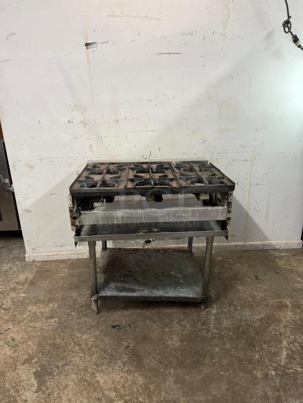 AMERICAN RANGE 36" commercial 6 burner range on a metal stand, shown in used condition.