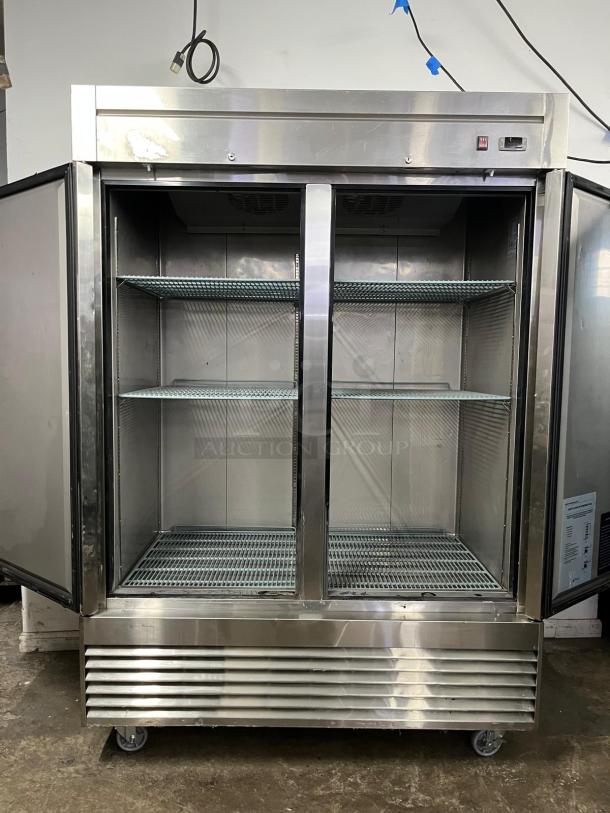 DUKERS D55R 55" stainless steel reach-in refrigerator, two sections, open doors, used, visible shelving, caster wheels.