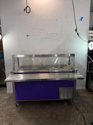 Delfield SCSC-60-EFP 60-inch refrigerated food serving counter, stainless steel, glass sneeze guard, with drain, on casters.