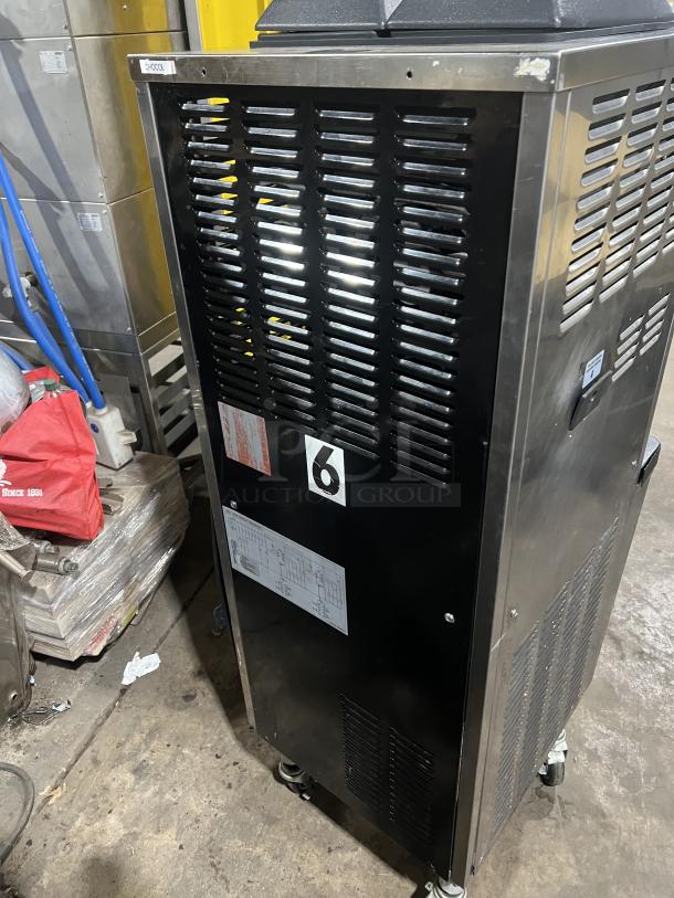 Well Spring SSI-143S commercial stainless steel ice cream machine, side view. Features 2 hoppers, drip tray, casters, and vented panels. Condition appears used.