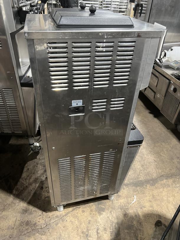 Well Spring SSI-143S stainless steel soft serve machine with 2 hoppers, 3 dispensers, digital controls, and drip tray. On casters.