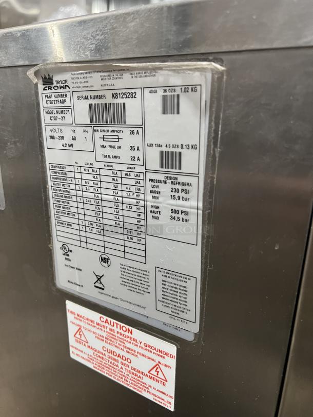 Taylor Flavor Burst Model C707-27 ice cream machine label showing serial number K8125282, voltage details, and safety warnings.