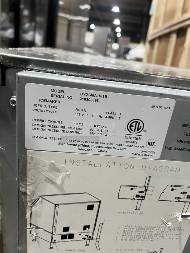 Manitowoc NEO Series ice machine, model UY0140A161B, stainless steel, air-cooled, on casters, 115V, shows label with specs.