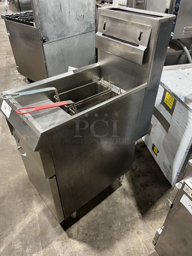 Pitco commercial stainless steel natural gas deep fat fryer with basket hanger, two fry baskets, backsplash, and casters.
