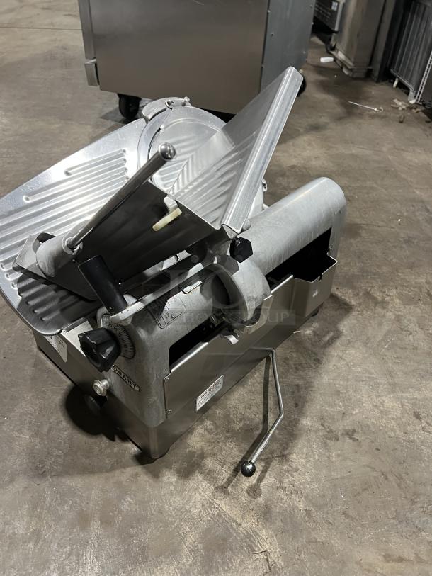 Hobart Model 1712 commercial stainless steel deli meat slicer, electric-powered, on legs, with visible condition labels.