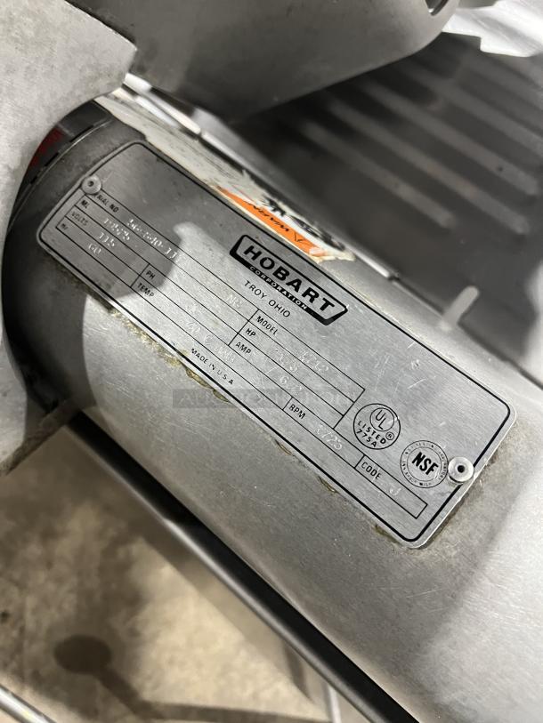 Hobart 1712 commercial deli meat slicer, stainless steel, electric, 115V, 1 phase, countertop model on legs, visible label.