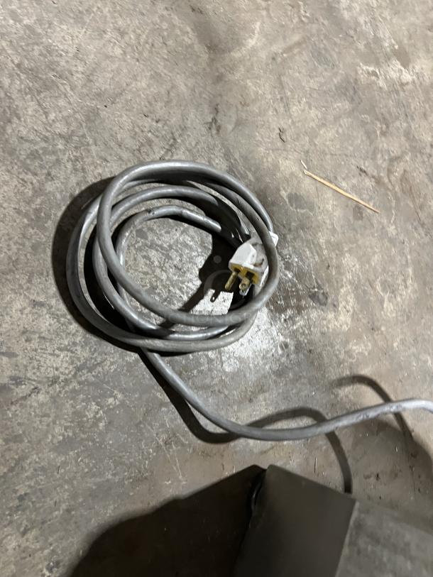 Hobart Model 1712 electric deli meat slicer's power cord, coiled on a concrete surface. 115V, 1Phase specification.