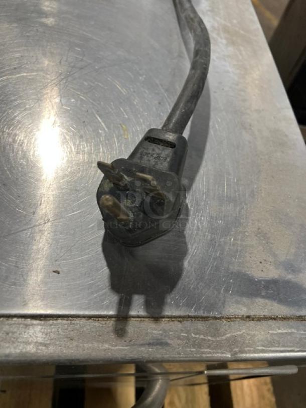 2011 Amana AXP20 commercial oven plug on stainless steel surface, showcasing electrical connection detail.