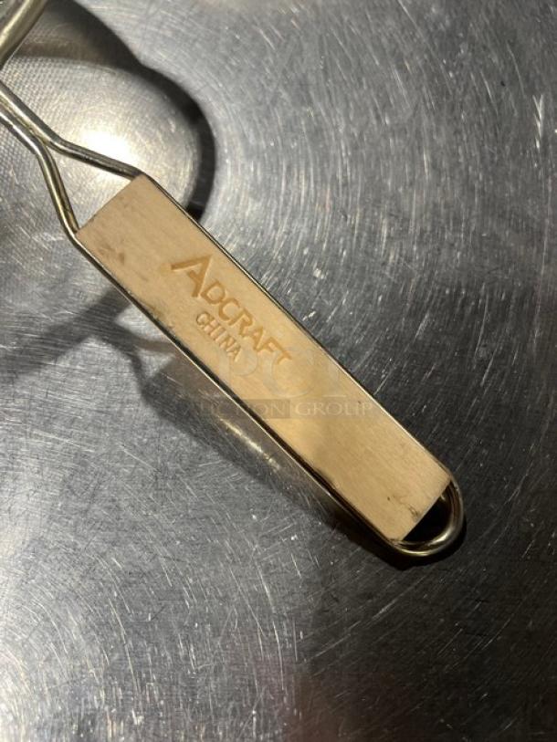 Adcraft stainless steel strainer with wooden grip handle, new condition. Brand engraved on handle. Ideal for heavy-duty use.