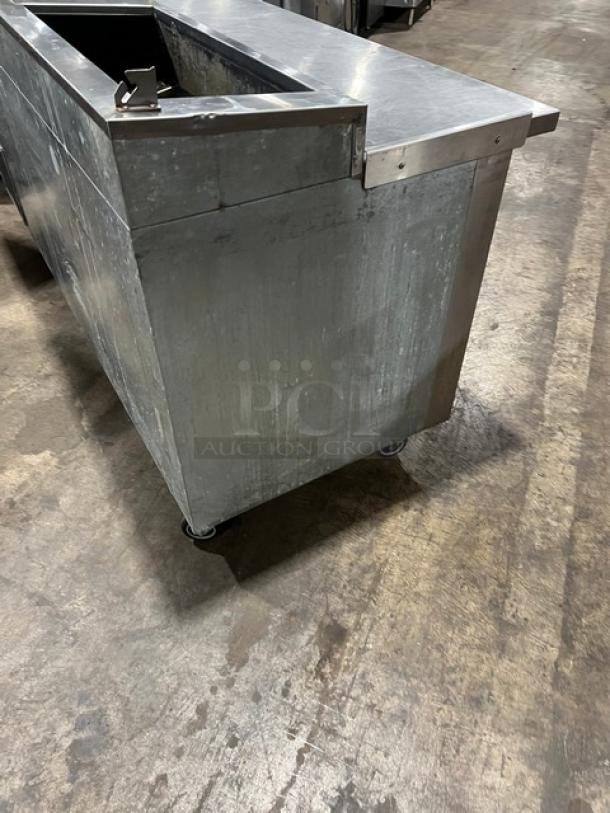 Universal Cooler stainless steel 3-door pizza prep table, on casters, with poly-coated wired rack. Commercial-grade condition.