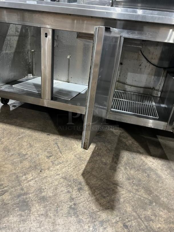 Universal Cooler commercial stainless steel 3-door pizza prep table, features poly-coated wired rack, mounted on casters.