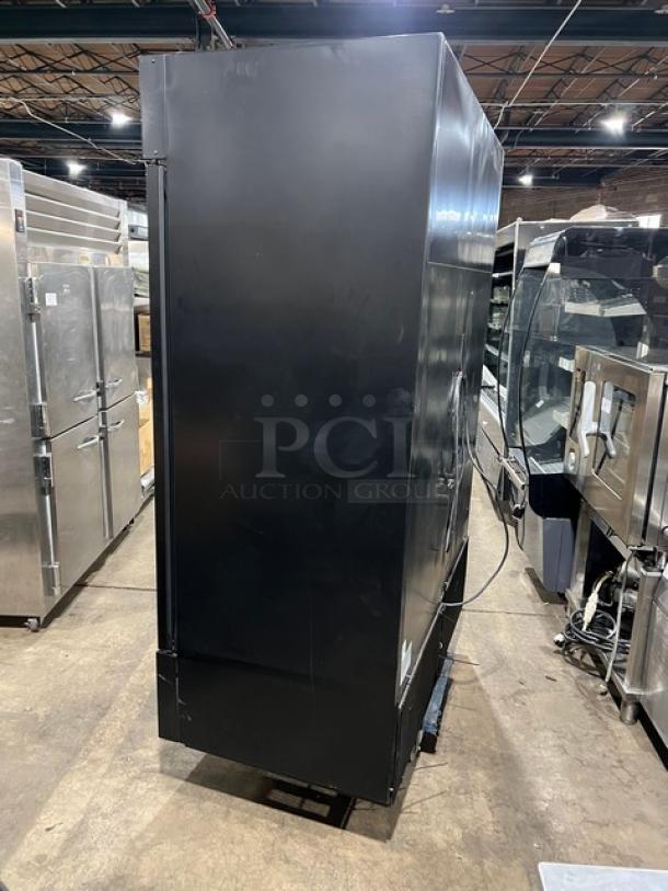 True Commercial Black Double Glass Swing Door Reach-In Merchandiser Refrigerator, Model GDM-49-HC~TSL01, in warehouse.
