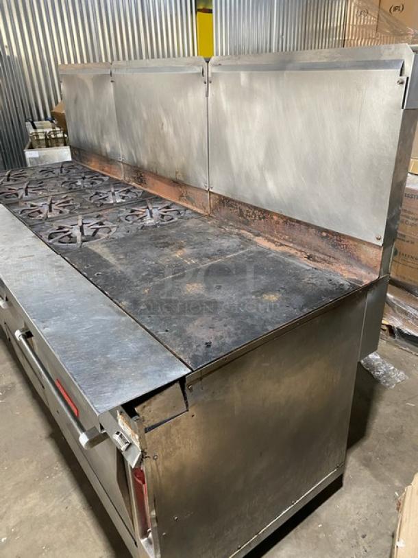 Vulcan stainless steel gas-powered 8-burner range with flat griddle, triple oven combo, backsplash, wire rack, and casters.