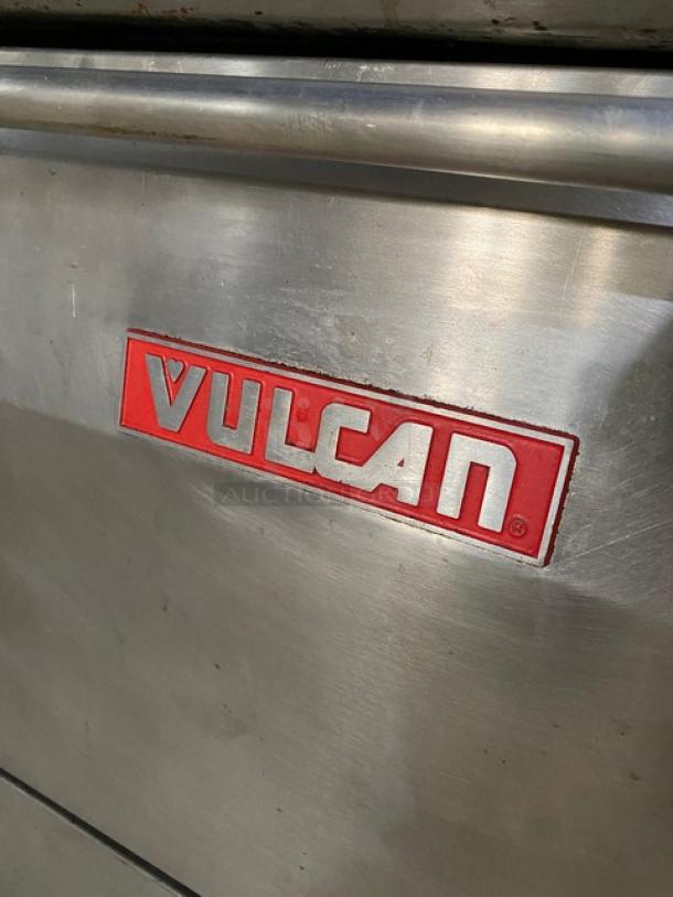 Vulcan stainless steel gas 8-burner range with griddle, triple oven combo, backsplash, wired rack, on casters, logo visible.