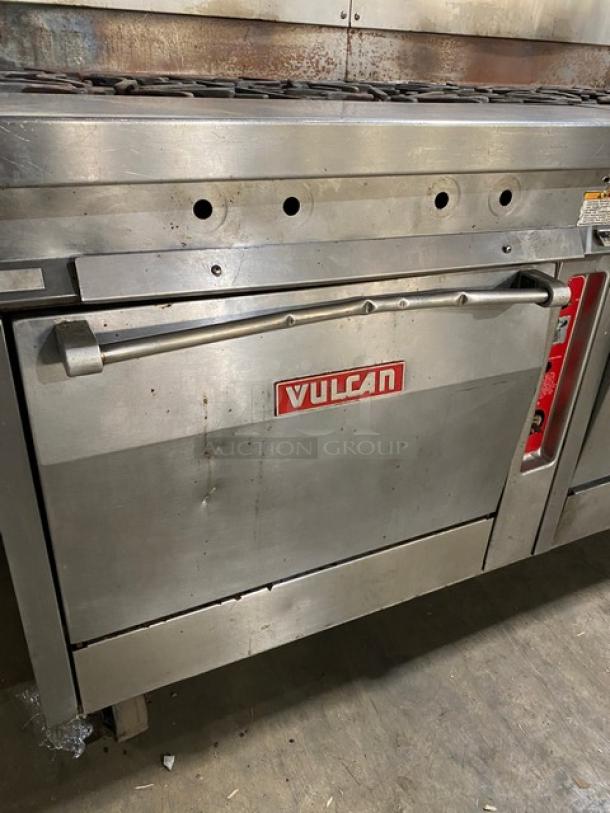 Vulcan commercial stainless steel 8-burner split-top griddle range with triple oven, backsplash, and wired oven rack on casters.