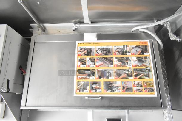 Nieco charbroiler grill with attached daily cleaning instructions showing maintenance steps in a mobile kitchen trailer.