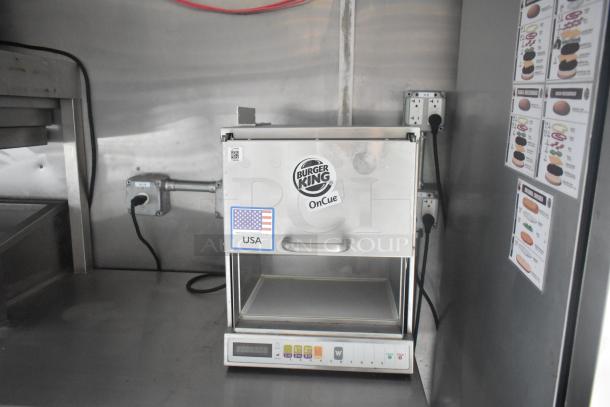 Burger King OnCue oven in mobile kitchen trailer, stainless steel, with USA label, digital panel, and menu guides on side wall.