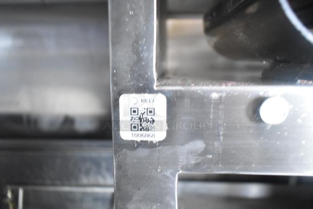 QR code and serial number sticker on metal frame of a mobile kitchen appliance in a Cruising Kitchens trailer.