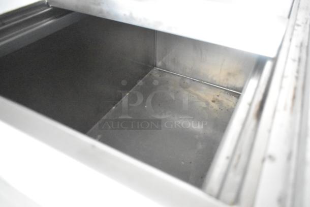 Interior view of a stainless steel compartment in the Cruising Kitchens 24' mobile kitchen trailer.