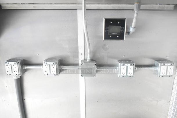 Interior view of a 2021 Cruising Kitchens Burger King fast food trailer, showing electrical outlets and CaptiveAire control panel.