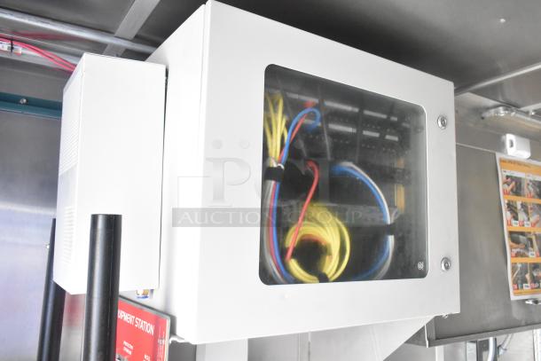 Mobile kitchen's equipment station showing network cables and fire suppression components, part of a 24' Burger King trailer setup.