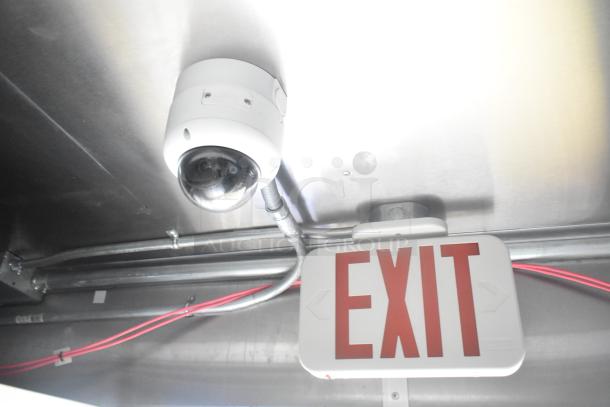 Security camera and exit sign inside mobile kitchen trailer, showcasing safety features.