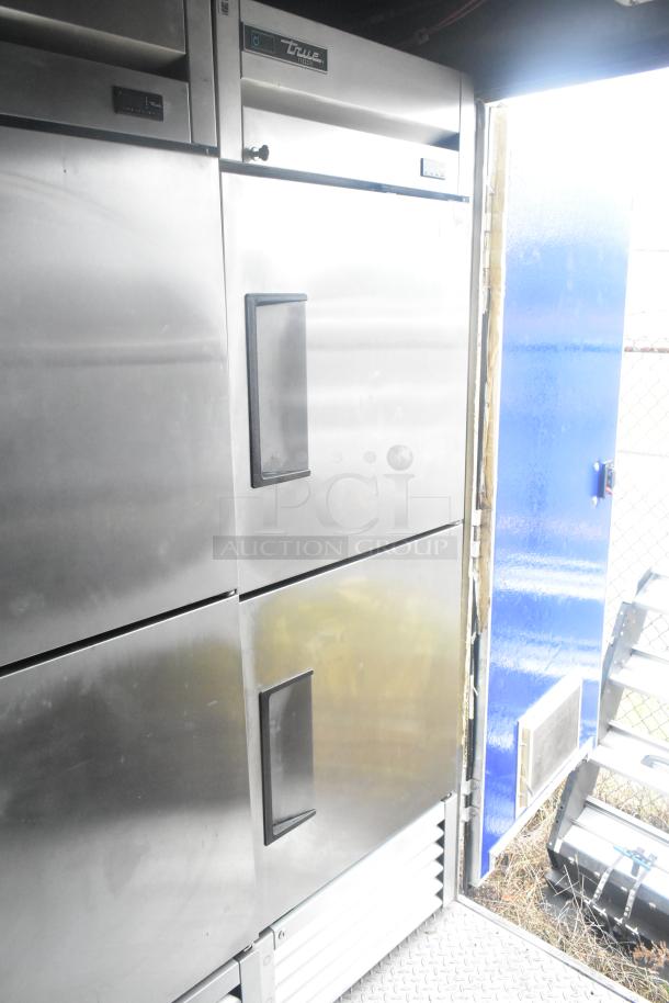 True reach-in commercial freezer and cooler inside mobile Burger King fast food trailer, showcasing stainless steel finish.