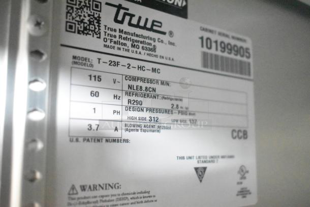Label displaying specifications for a True T-23F-2-HC-MC model refrigerator, including voltage, refrigerant type, and design pressures.