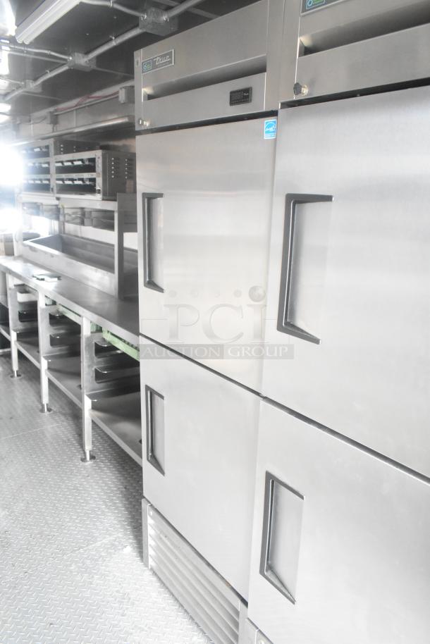 Cruising Kitchens 24' mobile kitchen with True freezers, Nieco charbroiler, CaptiveAire hood, and Frymaster fryer.