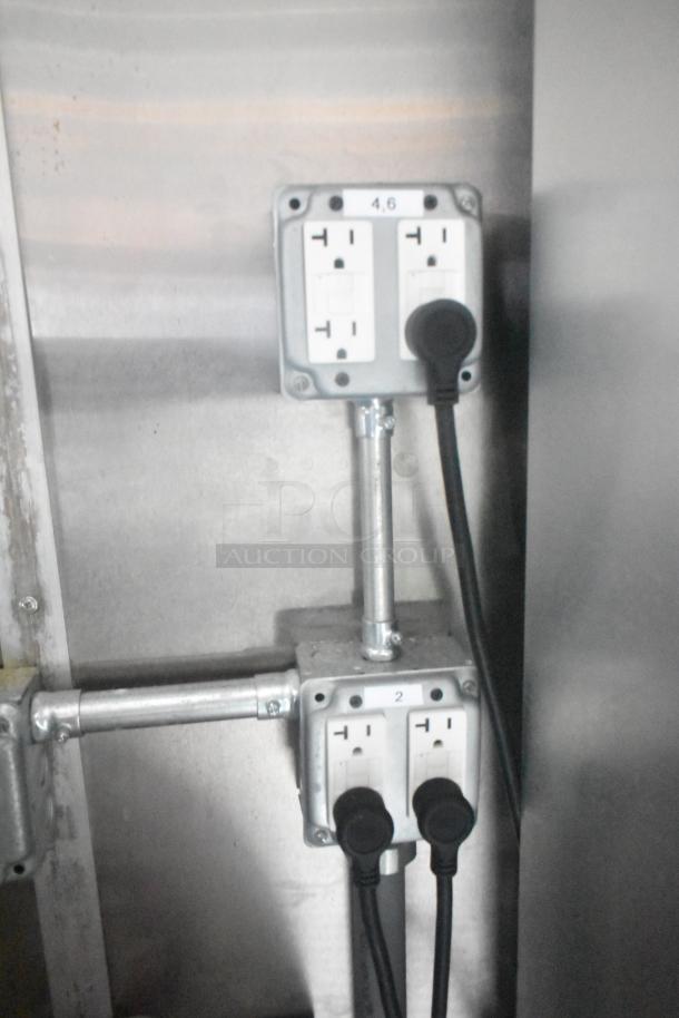 Electrical outlets inside the Cruising Kitchens 24' Burger King Fast Food Trailer, featuring labeled plugs and metallic conduit.