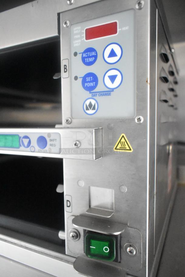 Close-up of mobile kitchen's control panel featuring temperature settings with arrows and hazard warning symbol.