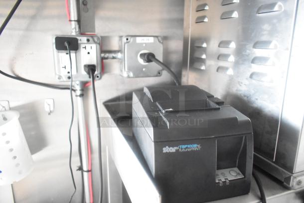 Star TSP100III futurePRNT thermal printer on countertop in mobile Burger King kitchen trailer, connected to power outlet.