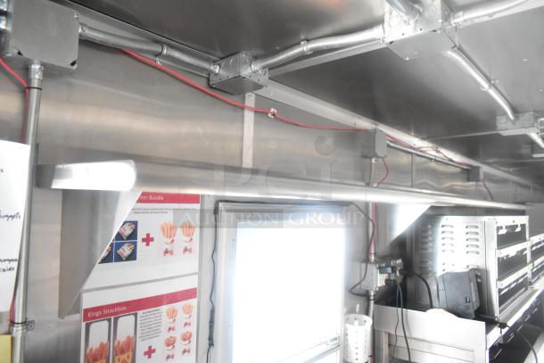 Interior of Cruising Kitchens 24' Burger King trailer, showcasing commercial-grade equipment including metal surfaces, wiring, and appliance areas.