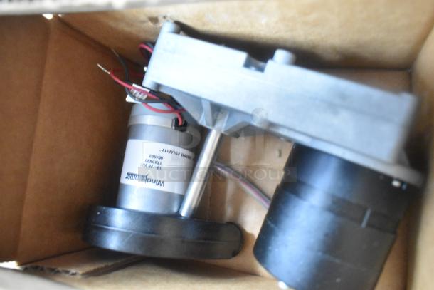 Close-up of Winchmaster motor inside a cardboard box, showing wiring and product label details.