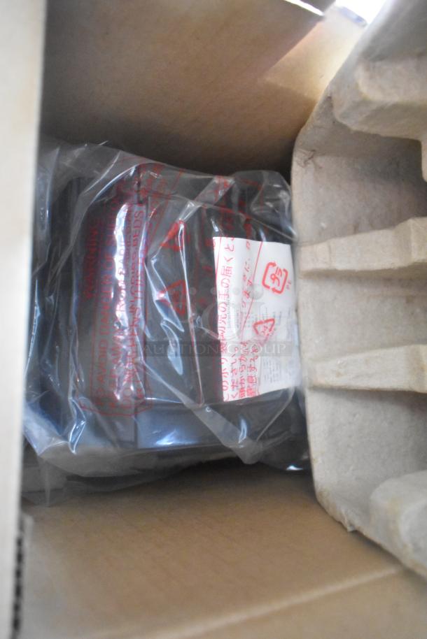 Packaging with safety warning label in multiple languages, showing a plastic-wrapped product inside a cardboard box.