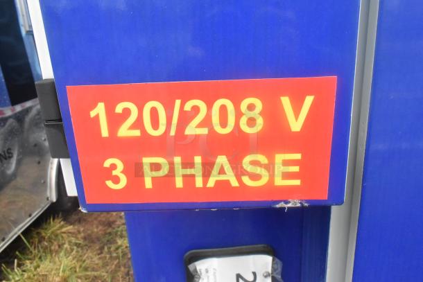 Sign on Burger King food trailer indicating 120/208 V, 3-phase power connection, necessary for commercial kitchen appliances.