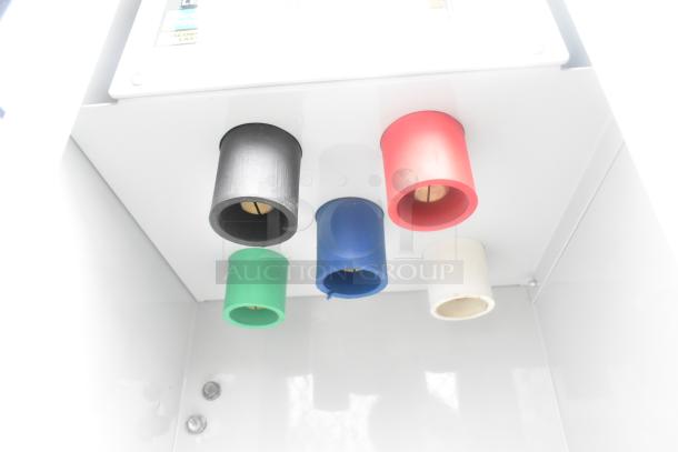 Color-coded dispensers inside a mobile kitchen trailer.