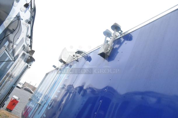 Exterior view of a 24' Cruising Kitchens Burger King mobile kitchen trailer in blue, equipped with commercial-grade appliances.