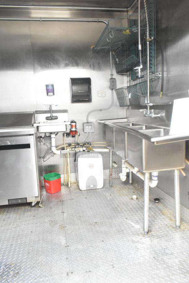 ATX 24' food trailer with stainless steel interior, three-compartment sink, Arctic Air prep table, and wall racks.