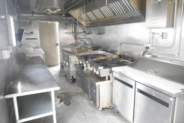ATX 24' food trailer with commercial kitchen, includes grease hood, gas range, fryers, prep tables; great condition.