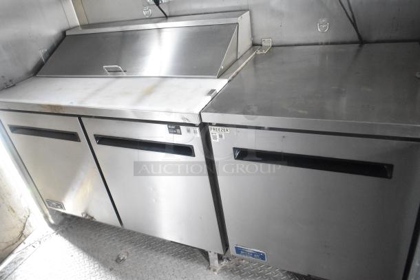 ATX 24' food trailer interior showing Arctic Air prep tables and freezer, stainless steel surfaces, commercial-grade fixtures.