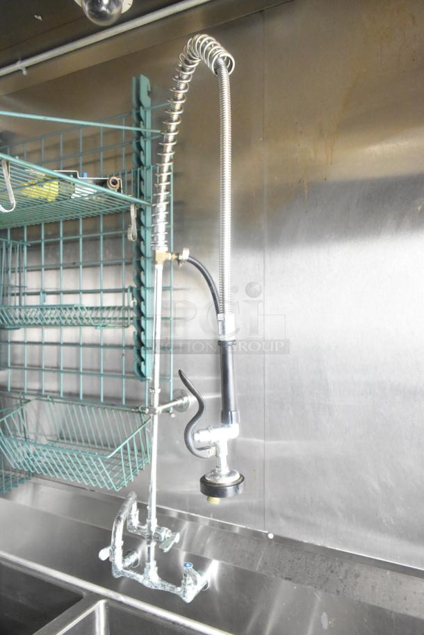 Commercial kitchen sink faucet with flexible hose in ATX 24' food trailer, featuring wall-mounted wire racks and stainless steel surfaces.