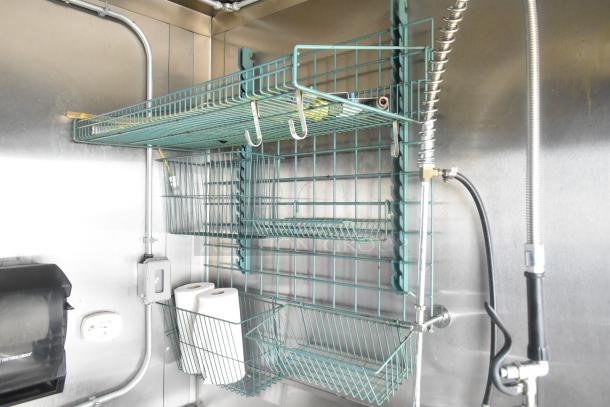 ATX 24' food trailer interior with stainless steel walls, wire shelving, and paper towel holder. Equipped for commercial use.