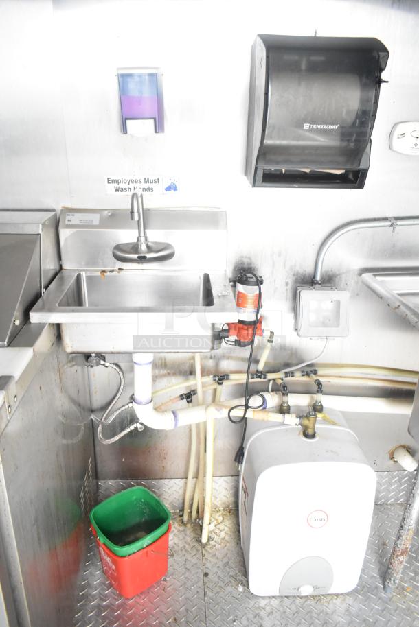 ATX food trailer interior with stainless steel sink, Thunder Group paper towel dispenser, soap dispenser, and Eemax water heater.