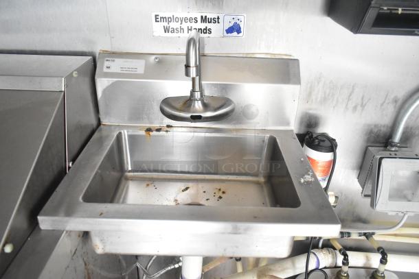 Stainless steel sink in ATX food trailer with "Employees Must Wash Hands" sign above. Visible piping and faucet.
