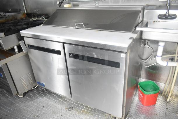 ATX 24' food trailer interior featuring Arctic Air prep tables, sink, and gas range. Fully equipped for commercial use.
