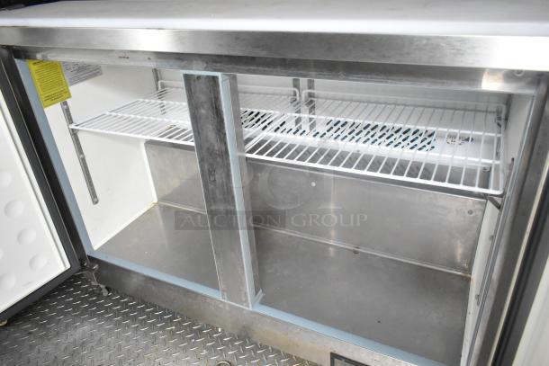 Interior view of ATX 24' food trailer, featuring stainless steel shelving and a walk-in prep area, ideal for commercial use.