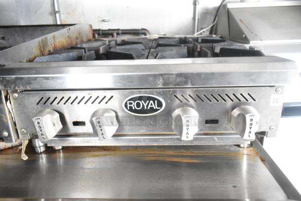 Royal gas range in food trailer, featuring four burners, stainless steel construction, control knobs labeled "Royal."