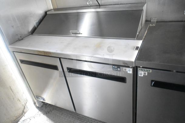 ATX 24' food trailer interior with stainless steel Arctic Air prep tables, freezer labels, and commercial-grade finish.